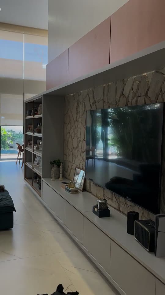 Sala com painel de TV em pedra e rack planejado